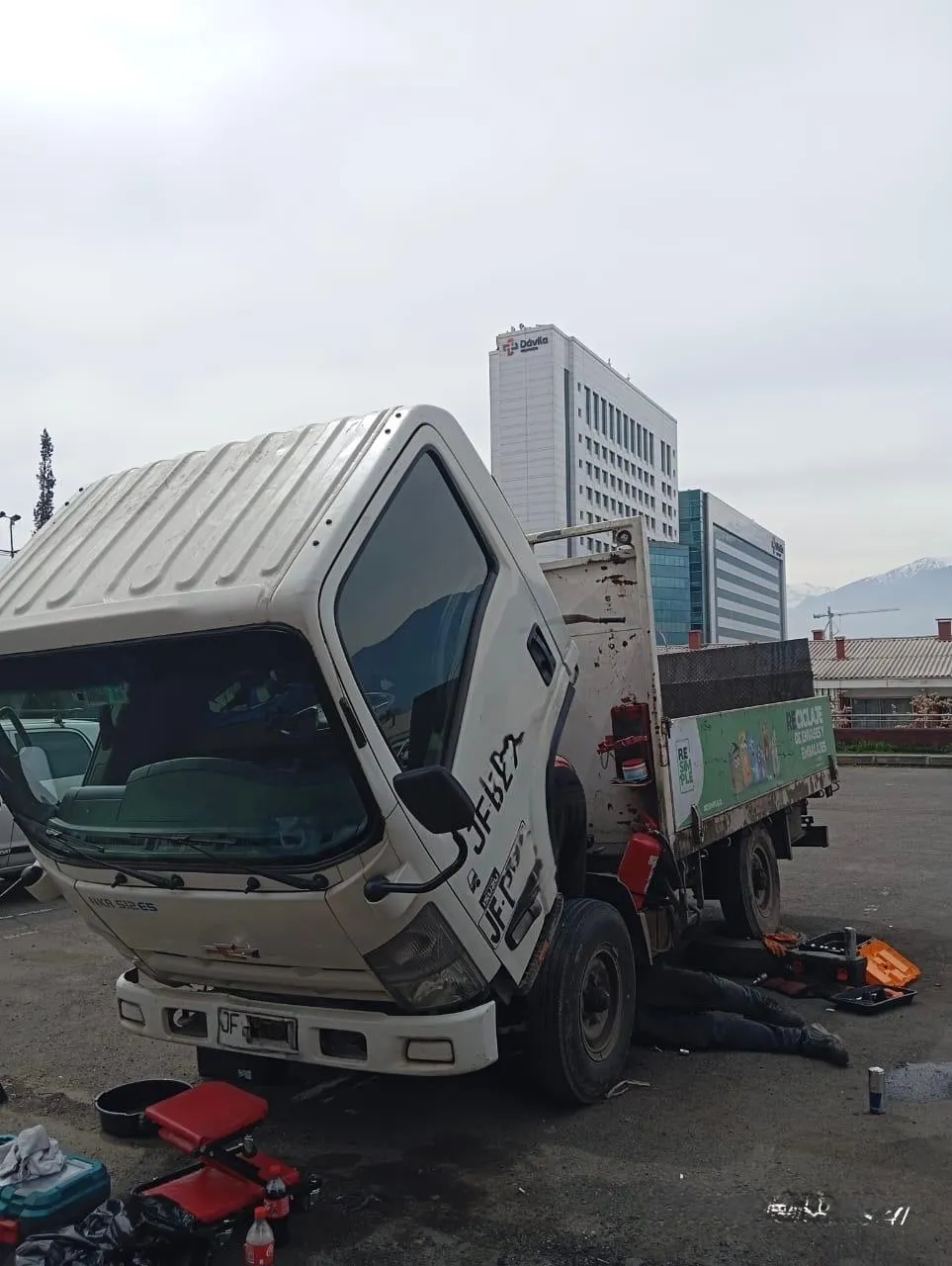 Mecánico trabajando bajo Chevrolet NKR 512 en cambio de embrague - DRAUTOMOTRIZ Peñalolén